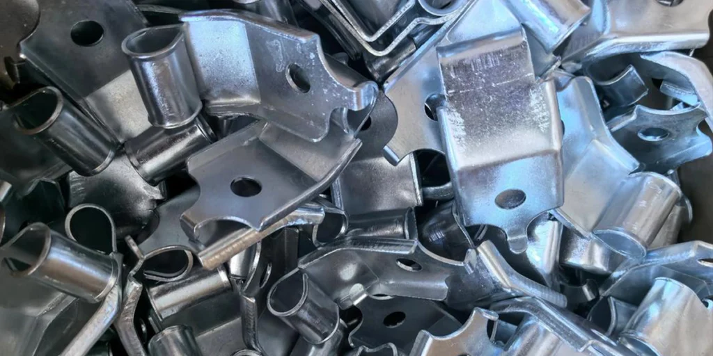 What is the sheet metal punching process? Sheet metal punching is a basic processing method in sheet metal processing. It refers to the process of punching out the required holes in a metal sheet in one go using a punch press and a die. Simply put, its core purpose is to efficiently and reliably "make holes" on sheet metal parts. In actual production, many people confuse punching, drilling, and piercing, but they are not exactly the same. • Punching: The process of forming a hole using a punch press and a die, utilizing instantaneous pressure. • Drilling: Creating holes by cutting material with a rotating cutting tool. • Drilling: A more colloquial term, usually referring to various methods of making holes. In the sheet metal processing industry, "punching" usually refers to the standard die-cutting process. To which category of sheet metal processing does punching belong? From a process classification perspective, sheet metal punching is a cutting/stamping process. It does not remove material through continuous cutting, but rather uses the cooperation between the punch and the die to cause the sheet metal to shear and fracture under pressure, thereby forming a hole. This processing method has distinct characteristics: • Fast forming speed • Good hole pattern consistency • Ideal for mass production The relationship between punching and sheet metal stamping In actual production, punching is usually a specific step in sheet metal stamping. In other words, stamping is a process system, and punching is one of the most common and basic operations within it. Besides punching, stamping may also include blanking, forming, flanging and other processes, but punching is often the first and most common step. The position of punching in the sheet metal manufacturing process In a complete sheet metal manufacturing process, punching typically occurs before forming or bending. Completing the hole machining before subsequent bending, joining, or assembly effectively ensures the positional accuracy of the holes and overall processing efficiency. For this reason, sheet metal punching is often regarded as a fundamental step in sheet metal processing, and its processing quality directly affects the smooth progress of subsequent processes. Sheet metal punching processing method In actual production, there is no single fixed method for punching sheet metal. Depending on the part structure, production volume, and cost requirements, factories usually choose different punching methods. From an application perspective, the most common methods of sheet metal punching are as follows. Punching with a punch press (traditional punching method) Punching is the most classic and common method of sheet metal punching. Using a punch press and a die, the hole is formed in a single punching motion. The characteristics of this method are: • High processing efficiency • Good consistency in hole position and size • Low processing cost per piece (in batch processing) More suitable situations: • The product structure is relatively fixed • Large production batches • Parts requiring high machining stability CNC punching (CNC punching machine punching) CNC punching is an upgrade from traditional punching, which completes the processing by controlling the punching position and sequence through a program. The characteristics of this method are: • Greater flexibility • Different hole positions can be quickly adjusted via the program. • Suitable for multi-variety, small to medium batch production. More suitable situations: • Product specifications vary considerably • Do not want to frequently change complex molds • Sheet metal parts that require a balance between efficiency and flexibility Dense-hole punching (for structures with dense holes) When a large number of regularly arranged holes need to be machined on sheet metal parts, a dense hole punching method is usually used. The characteristics of this method are: • Can complete the machining of multiple holes at once • Processing efficiency has been significantly improved • Better hole spacing consistency More suitable situations: • Sheet metal parts for ventilation and heat dissipation • Regular, repeating hole pattern Other auxiliary processing methods In certain special cases, laser cutting or other methods may be used to complete the "hole making" requirement, but these methods are not typical sheet metal punching processes and are more often used for prototyping, small batches, or special structural parts. Common hole types for sheet metal punching In sheet metal punching, the choice of hole shape is not arbitrary. Different hole shapes not only affect the appearance, but also directly relate to functionality, strength, and processing difficulty. In practical applications, the most common hole types in sheet metal punching are mainly concentrated in the following categories. round hole Round holes are the most common and easiest type of hole to process in sheet metal punching. Typical applications: • Ventilation and heat dissipation • Bolt and rivet mounting holes • Decorative openings Round holes have uniform stress distribution, good processing stability, and minimal impact on materials, making them the preferred hole type for most sheet metal parts. Square hole Square holes have distinct right-angled edges and a regular appearance. Typical applications: • Frame structure • Panel opening • Functional connectors Compared to round holes, square holes require slightly higher precision in mold making and machining, but they are very common when a regular structure is needed or when matching square parts. Oblong hole (slender hole) The oblong hole is between a round hole and a square hole, balancing the opening size and structural strength. Typical applications: • Mounting adjustment hole • Sliding structure • Locations requiring a certain installation margin This type of hole is very practical in structural design, as it facilitates assembly and does not easily weaken the strength of the sheet metal. Irregular holes Irregular holes typically refer to holes with non-standard geometric shapes, which can be customized according to product requirements. Typical applications: • Special functional structure • Sheet metal parts with high requirements for appearance design • Location or identification purposes It should be noted that irregularly shaped holes are usually more difficult to process, and the requirements for mold design and processing stability are also more stringent. A brief explanation of hole type and machining difficulty Generally speaking: • The more regular the hole shape, the easier it is to process. • The more complex the shape, the higher the requirements for the process and mold. Therefore, under the premise of meeting functional requirements, prioritizing simple and regular hole shapes helps to improve processing stability and control costs. Application areas of sheet metal punching The reason why sheet metal punching technology is widely used is that it can meet the structural and functional requirements while also taking into account efficiency and consistency. In actual products, punching is often not "for the sake of processing", but directly serves a specific purpose. The following are the most common and typical application scenarios for sheet metal punching. Chassis, cabinet and equipment enclosure In chassis and cabinet products, sheet metal punching is almost an essential process. Common uses include: • Equipment heat dissipation holes • Cable perforation • Mounting holes These types of products typically require high consistency in hole positions and uniformity in appearance. The punching process can maintain good structural stability while ensuring efficiency. Ventilation and heat dissipation structure Ventilation and heat dissipation are among the most intuitive and common applications of sheet metal punching. Typical scenarios include: • Ventilation hood • Heat dissipation panel • Air duct structural components By using appropriate hole shapes and arrangements, punching can not only allow airflow but also control noise and structural strength to a certain extent, which is a standard practice in many industrial equipment. Installation and connection structure In various sheet metal parts, punching is often used for subsequent assembly and fixing. Common features include: • Bolt and screw mounting holes • Riveting holes • Positioning holes This type of punching is usually used in conjunction with bending and joining processes, and is a key step in ensuring assembly efficiency and consistency. Applications that combine functionality and aesthetics In some products, punching not only serves a functional purpose but also affects the overall appearance. Common purposes include: • Reduce the weight of parts • Enhance visual hierarchy • Achieve a regular decorative effect Without compromising strength, the proper use of perforation structures can achieve a balance between functionality and aesthetics in sheet metal parts. Disadvantages of sheet metal punching process In actual product selection, whether to adopt sheet metal punching technology often depends on a core issue: whether it is "more suitable" under the current product conditions. Below, we'll discuss the advantages and limitations to help you quickly determine whether it's worth using. Main advantages of sheet metal punching process 1. High processing efficiency, suitable for mass production. The punching process can complete the hole formation in one operation, and it has a stable cycle time and outstanding efficiency in mass production, making it particularly suitable for parts with high repetition. 2. Good hole alignment and stable assembly. Processing with molds or CNC punches ensures high consistency in hole position and size, which is beneficial for subsequent assembly, riveting, or bolting. 3. Significant cost advantage under batch production conditions In medium to large-volume production, the low cost of processing a single piece makes it a common choice for controlling overall manufacturing costs. Limitations of sheet metal punching process 1. There are certain limitations on materials and thickness. If the material is too thin, it is easy to deform; if it is too thick, it will require more sophisticated equipment and molds, and is not suitable for all sheet material conditions. 2. High dependence on molds When non-standard hole shapes or frequent design changes are made, the cost of mold investment and adjustment will increase significantly. 3. Relatively limited design flexibility Once the hole shape and layout are determined, later modifications are not as convenient as some flexible processing methods, making them more suitable for products with already finalized designs. At last In summary, sheet metal punching is a mature, stable, and highly practical sheet metal processing method. It is particularly suitable for sheet metal parts with regular hole shapes, relatively fixed structures, and requirements for processing consistency and efficiency. During the product design phase, if a part requires a large number of repetitive holes and is subsequently involved in assembly, connection, or heat dissipation structures, then punching is often a more balanced option in terms of efficiency and cost. However, it is also necessary to make a comprehensive judgment based on the material thickness, hole complexity, and production volume to avoid increasing subsequent adjustment costs due to improper process selection. Understanding the characteristics and applicable scope of sheet metal punching technology helps in making more reasonable decisions that are more in line with actual production conditions when formulating sheet metal processing plans.